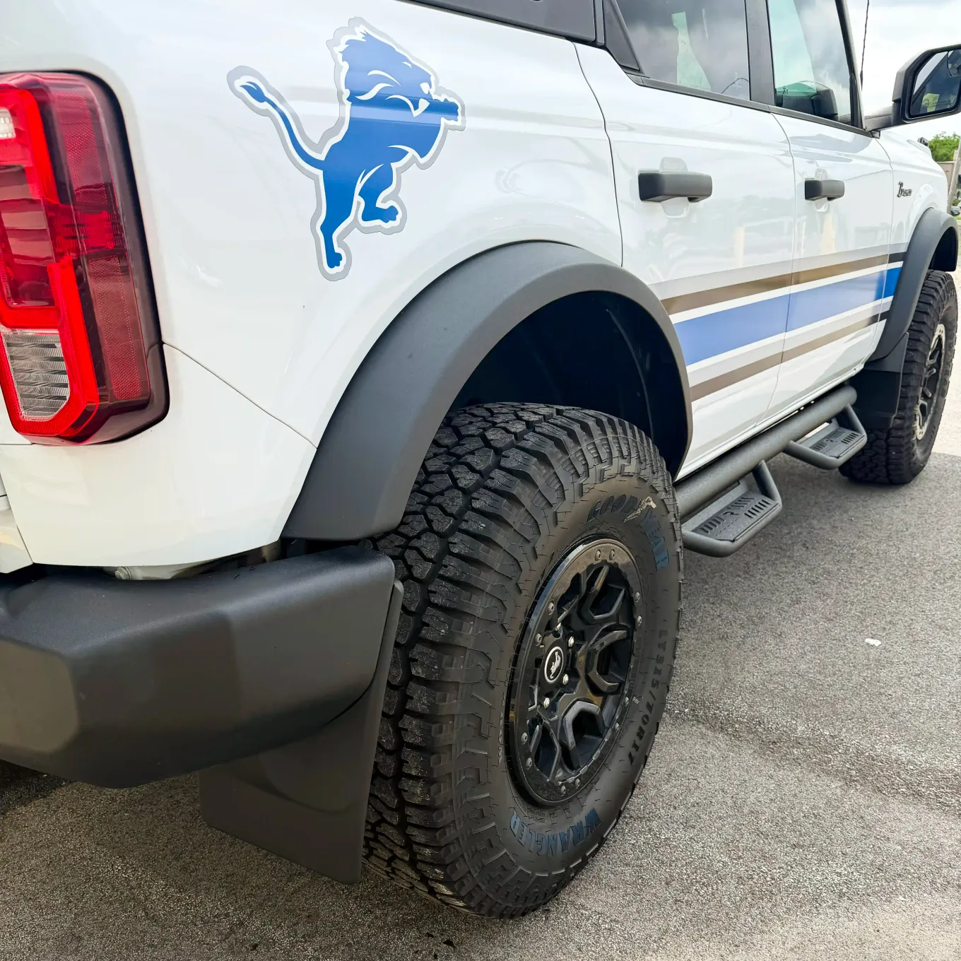 White Ford Bronco with Detroit Lions graphic, coated fender flares and step bars